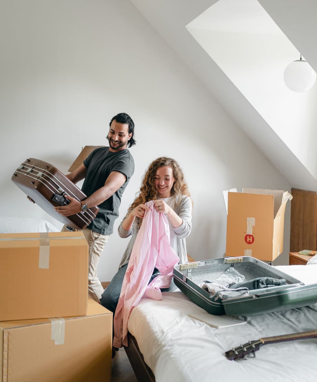 Two people packing their belongings into suitcases and moving boxes