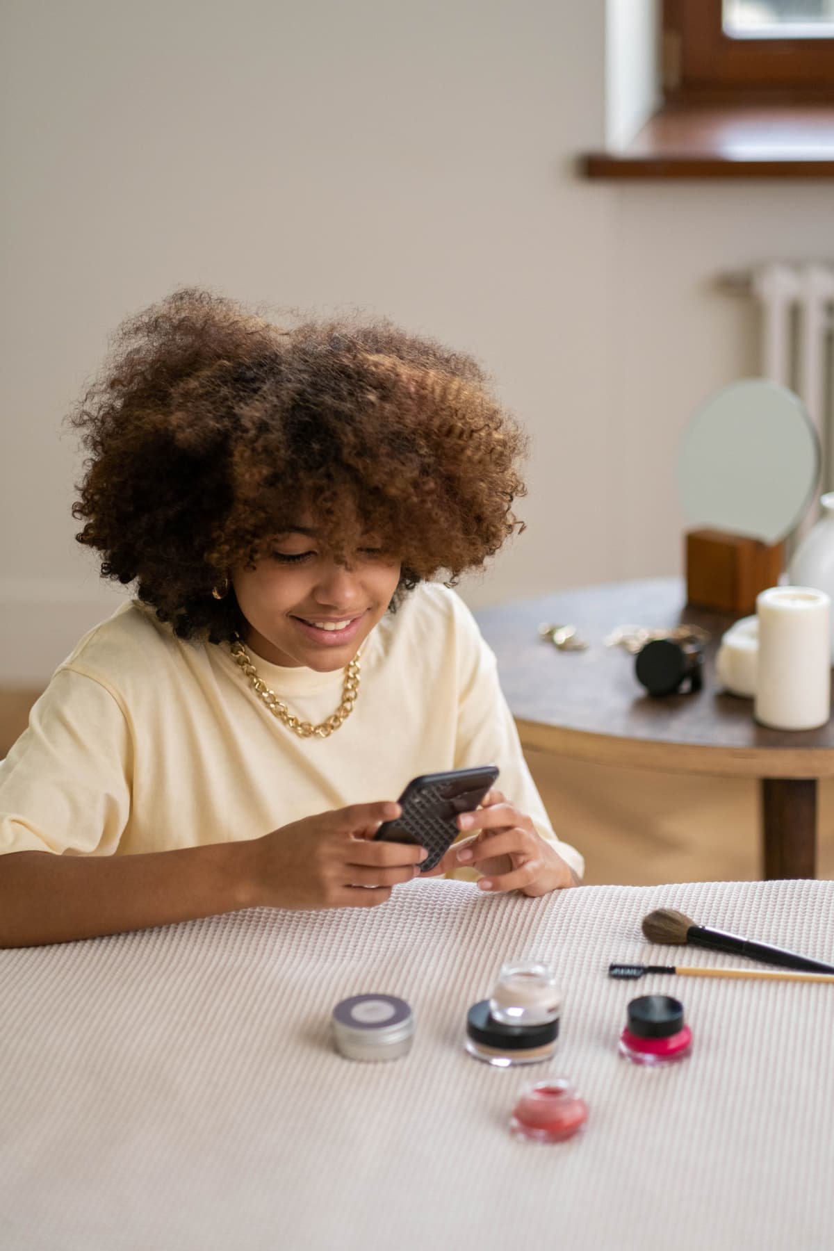 A woman browsing her phone at a dressing table